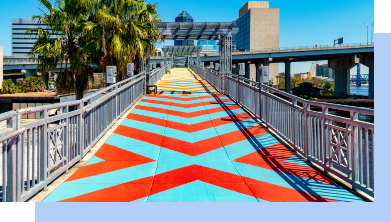 The colorful painted sidewalk of The Riverwalk with the skyline of Jacksonville, Florida.