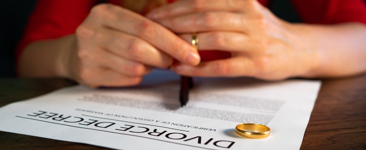 Woman signs divorce papers and removes her ring