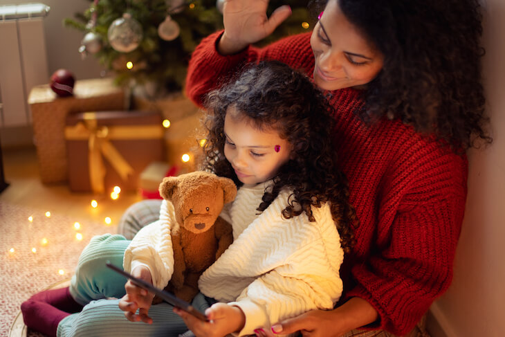 mother sits with daughter on lap during holiday season