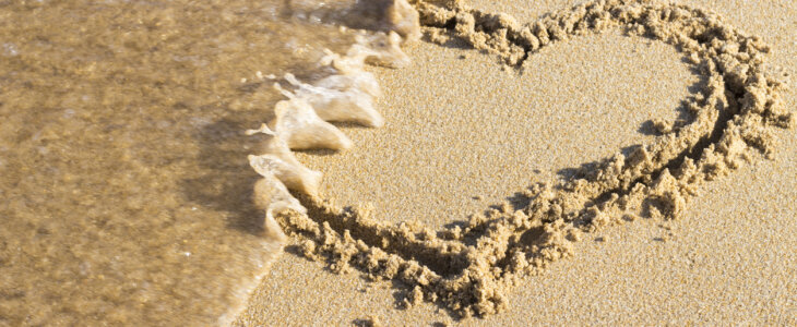 heart drawn on sand is washed off by sea wave, top view End relationship.