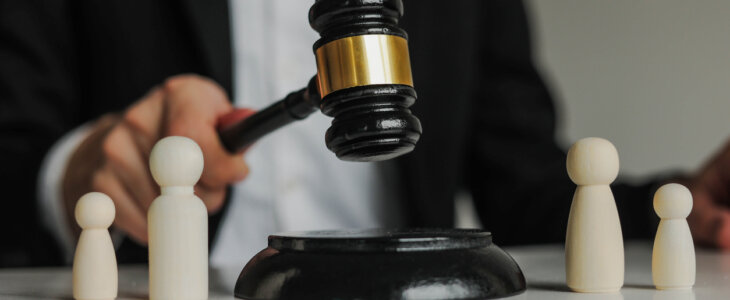 Figures of family are separated by judge's gavel. Family law, divorce lawyer and alimony concept.