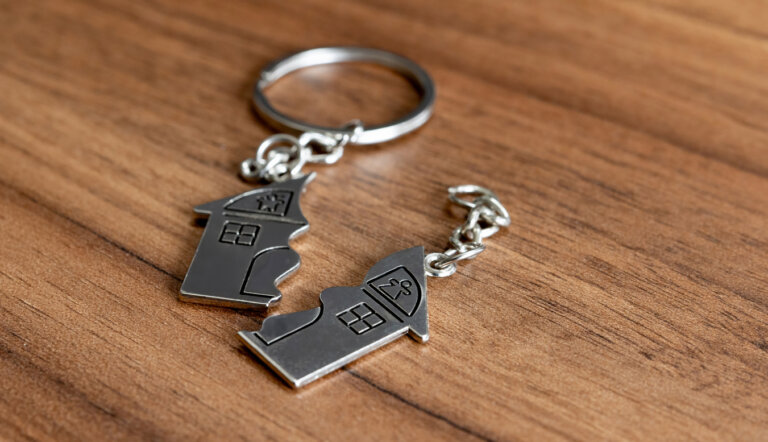 Close-up on a broken house keyring on a wooden table - divorce concepts