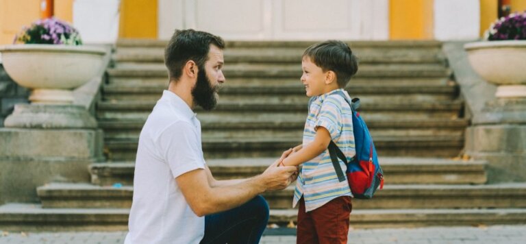 Father helping his young son with his backpack