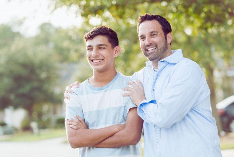 Father standing with his teenage son outdoors