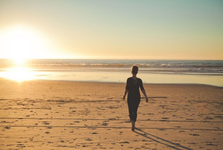 Woman walking along a Florida beach at sunset