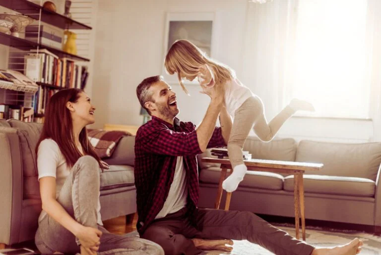 Parents playing with their young daughter at home