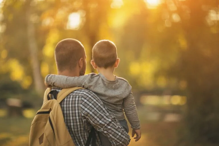 Father carrying his young son outdoors